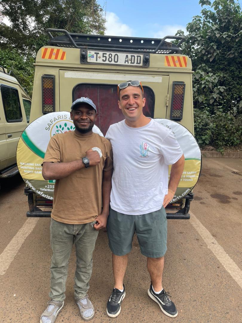 Safari and Bush Retreats team beside a safari vehicle on the Tanzanian plains